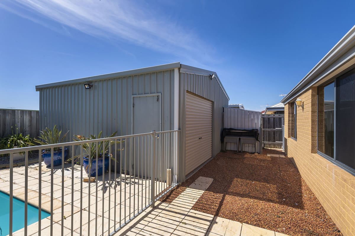 Poolside area with shed and fencing.