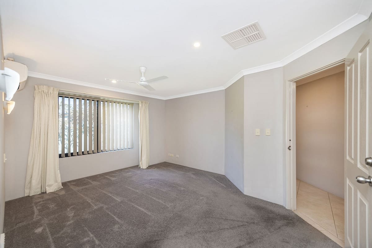 Spacious, carpeted room with natural light.