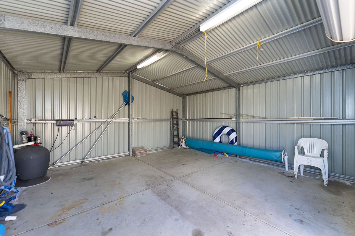Spacious, empty garage with minimal furnishings.